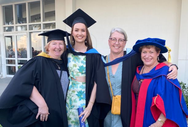 Kira at her graduation with her midwifery lecturers. 